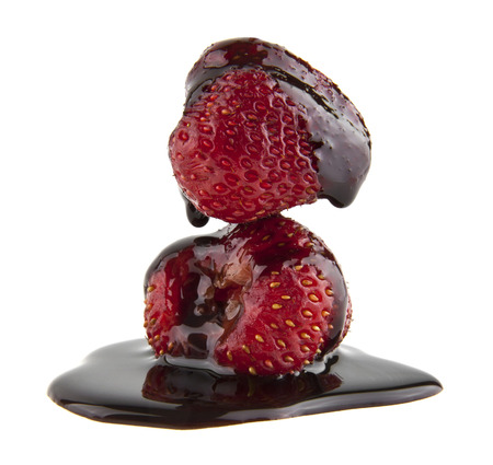 strawberry in chocolate syrup isolated on white backgroundの写真素材
