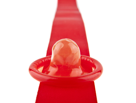 red tape and condom isolated on white background close-upの写真素材