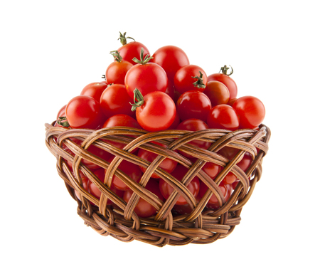 tomatoes in a basket isolated on white background close-upの写真素材