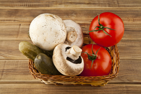 tomatoes, cucumbers and mushrooms on wooden background closeupの写真素材