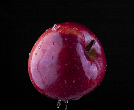 apples in drops of water on black backgroundの写真素材