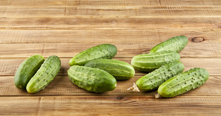fresh, juicy green cucumbers on wooden backgroundの写真素材