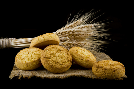 homemade cookies and spikelets isolated on a black backgroundの写真素材