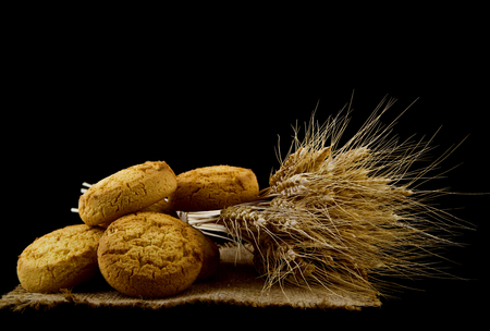homemade cookies and spikelets isolated on a black backgroundの写真素材
