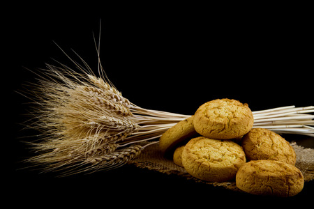 homemade cookies and spikelets isolated on a black backgroundの写真素材