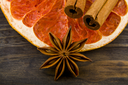 dried grapefruit, cinnamon sticks and anise stars on wooden backgroundの写真素材