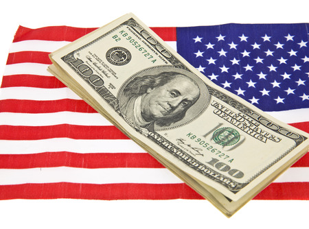dollars on usa flag isolated on white backgroundの写真素材