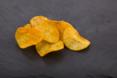 potato chips on a black stone background close-upの写真素材