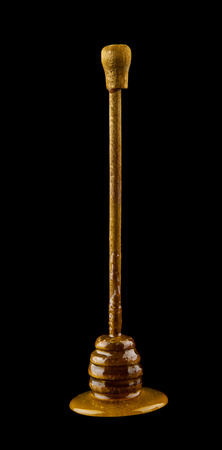 Wooden spoon with honey isolated on black backgroundの写真素材