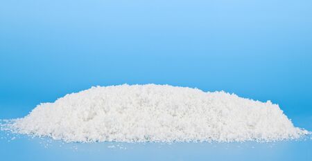 A pile of fluffy white snow on a blue background. Background for christmas and new year holidays.の写真素材