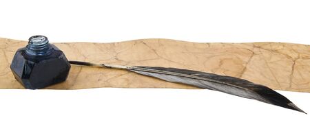 Inkwell with feather and old paper isolated on whiteの写真素材