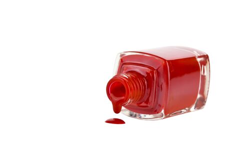 Opened bottle with spilled red nail polish isolated on a whiteの写真素材