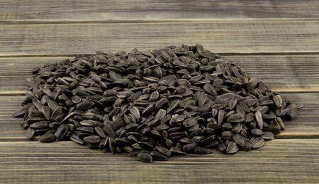 A pile of sunflower seeds on a wooden table close-up.の写真素材