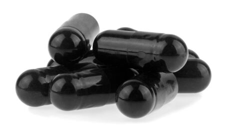 Black activated carbon pills isolated on whiteの写真素材