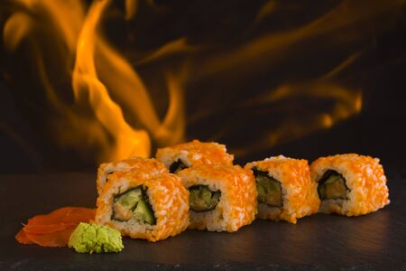 Sushi isolated on a black background on fire close-up.の写真素材