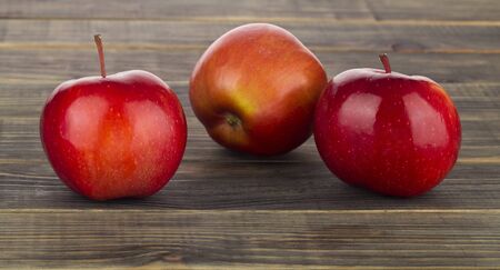 Red apples on a wooden background close-up.の写真素材