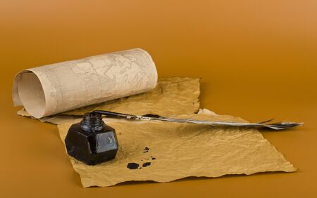 Old paper, inkwell and pen on a brown background close-up.の写真素材