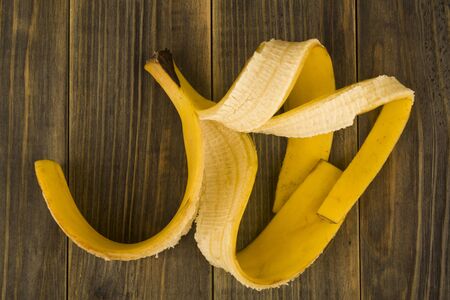 Banana skin on a wooden background close-up. View from above.の写真素材