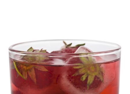 Glass with a cold red drink and with strawberries in ice cubes Isolated on a white background.の写真素材