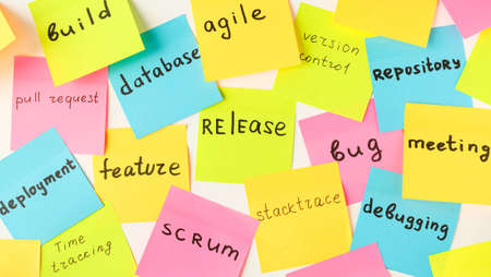 Multi-colored square stickers with terms from the IT field - release, bug, meeting, feature, database, agileの写真素材