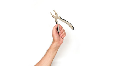 Male hand holding a pliers with a red handle on a white backgroundの写真素材