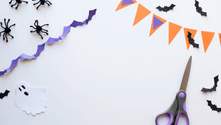 Halloween paper craft background with place for text - scissors, paper bats, ghost, garland and spidersの写真素材