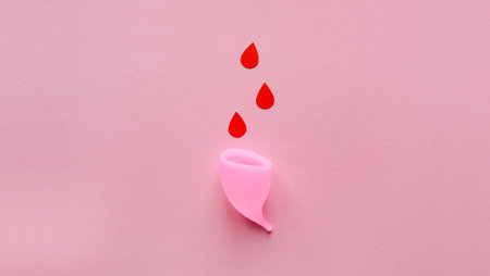 Menstrual cup and drops of blood on a pink backgroundの写真素材
