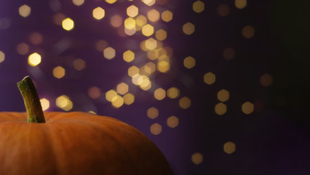 Close-up orange pumpkin with selective focus on golden bokeh backgroundの写真素材