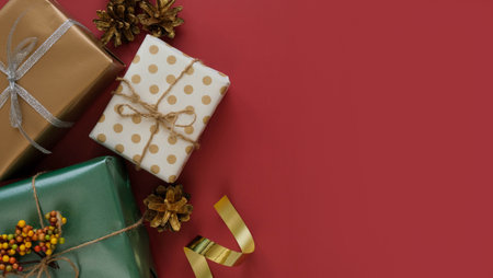 Different wrapped boxes with gifts top view on a red background with a place for text