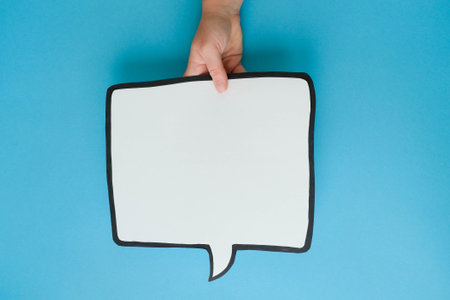 Speech bubble in hand on a blue background. Comic cloud with a place for text