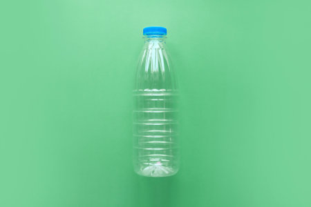Empty transparent plastic bottle on a green backgroundの写真素材