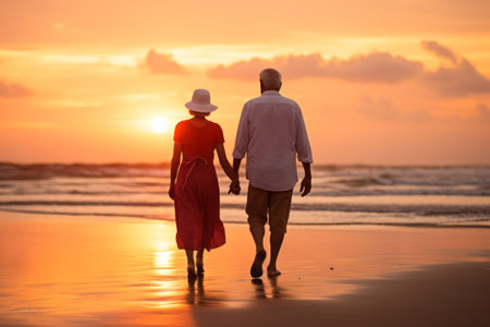 Senior couple walks on beach at sunset, back view. AI generativeの素材