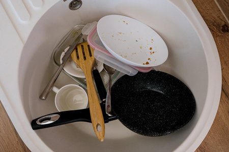 A pile of dirty dishes in the kitchen sink, top viewの写真素材