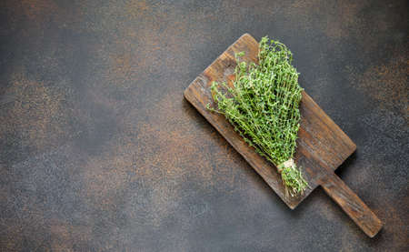 Culinary background with fresh thyme on a wooden Board in a rustic style, vintage dark backgroundの写真素材