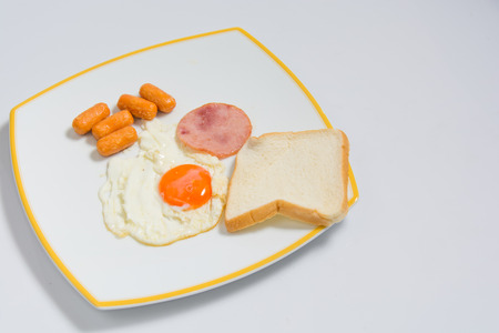 breakfast with ham , fried eggs on white plate. for textの写真素材