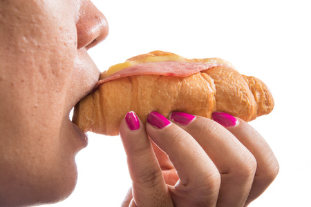 woman  eating croissant with hotdog isolated on white backgroundの写真素材