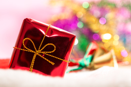 Christmas background with bokeh and red gift box in snowの写真素材