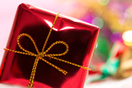 Christmas background with bokeh and red gift box in snowの写真素材