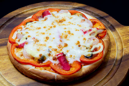 Delicious pizza served on wooden plateの写真素材