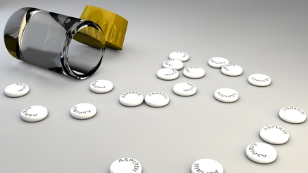Spilled aspirin pills and bottle on gray backgroundの写真素材