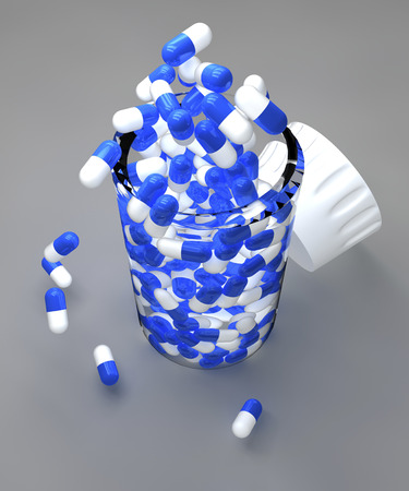 Spilled blue pills and bottle on gray backgroundの写真素材