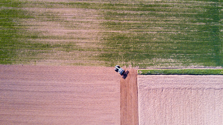 Tractor plowing the fields, aerial view, plowing, sowing, harvest. Agriculture and Farming, campaignの写真素材