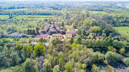Nature and landscape: Aerial view of a furnace and chimney, woods and lakes, and green trees in a wild landscape. Groane Park, town of Mombello (Laghettone) Limbiate, Milano, Italyの写真素材