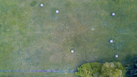 Nature and landscape: Aerial view of a field, plowed field, cultivation, green grass, countryside, farming, haystacks, hay balesの写真素材