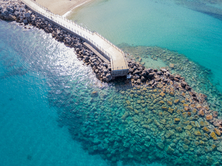 Aerial view of a pier with rocks and rocks on the sea. Pier of Pizzo Calabro, panoramic view from above. Summer sea and tourism on the Calabrian coast of Southern Italy. Calabria, Italyの写真素材