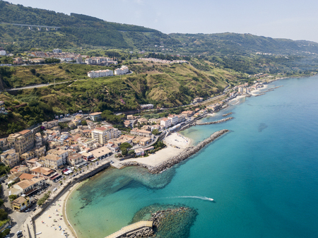 Aerial view of a beach and a pier with canoes, boats and umbrellas. Pizzo Calabro, Calabria, Italyの写真素材