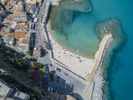 Aerial view of a beach and a pier with canoes, boats and umbrellas. Pizzo Calabro, Calabria, Italyの写真素材