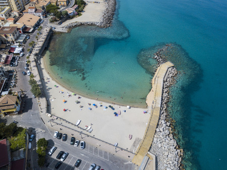 Aerial view of a beach and a pier with canoes, boats and umbrellas. Pizzo Calabro, Calabria, Italyの写真素材