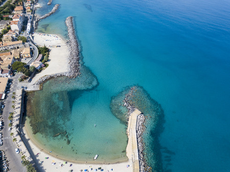 Aerial view of a beach and a pier with canoes, boats and umbrellas. Pizzo Calabro, Calabria, Italyの写真素材