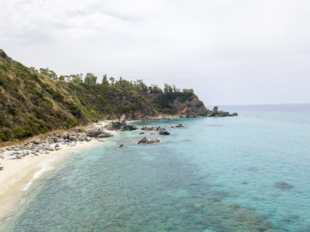 Paradise of the sub, beach with promontory overlooking the sea. Zambrone, Calabria, Italy. Diving relaxation and summer vacations. Italian coasts, beaches and rocks. Aerial viewの写真素材